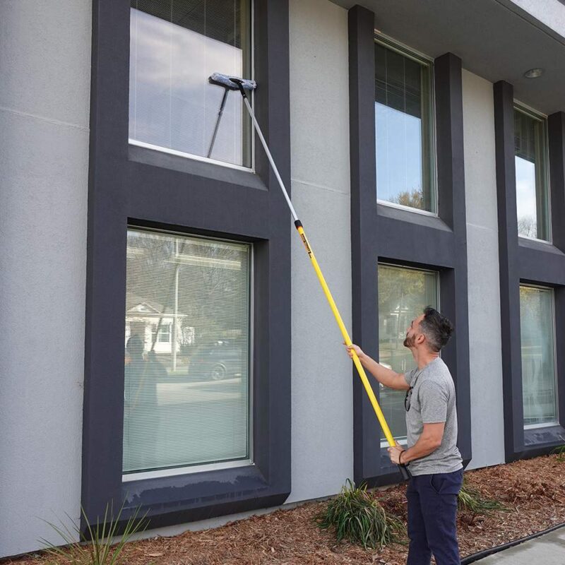 Man cleaning windows using the Pro-Lok pole and ProDesign Window Cleaning kit