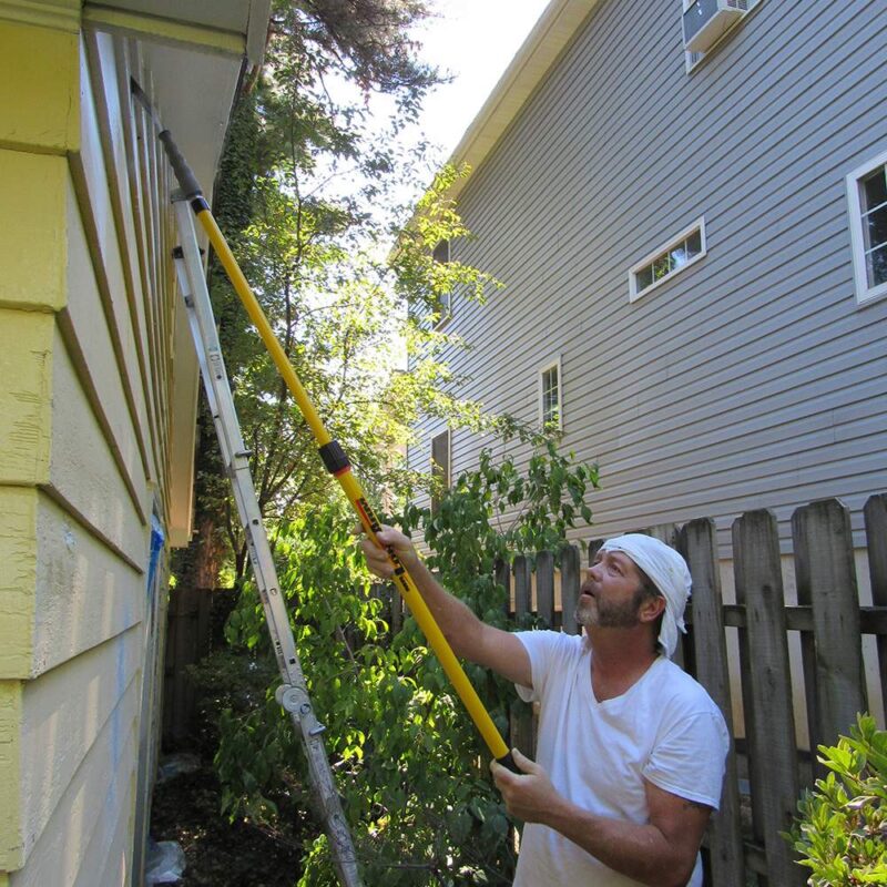 Contractor using a Pro-Pole Fiberglass to scrape paint