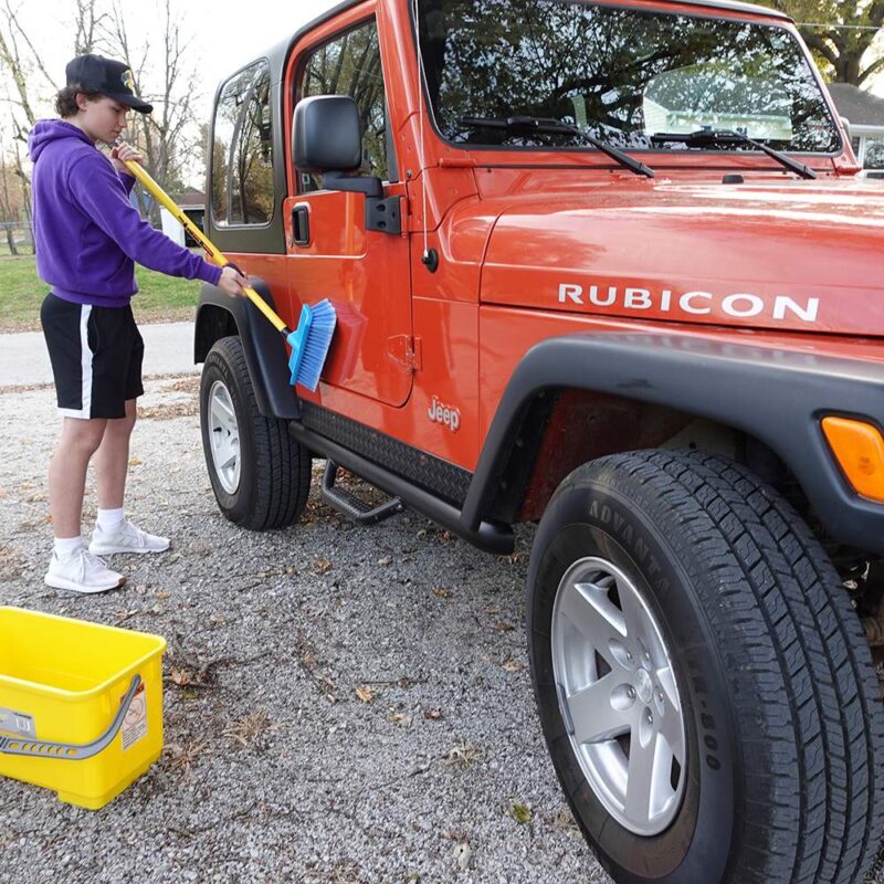 Pro-Pole Fiberglass cleaning a red jeep with a brush