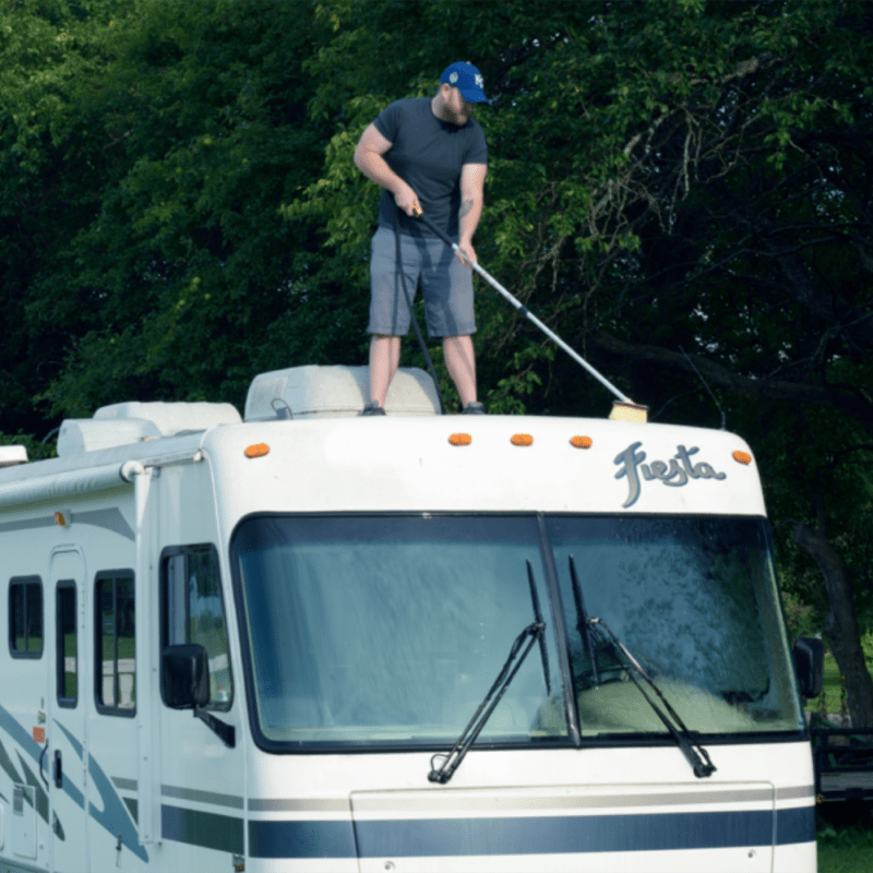 Stiff flow-thru brush cleaning the roof of an RV