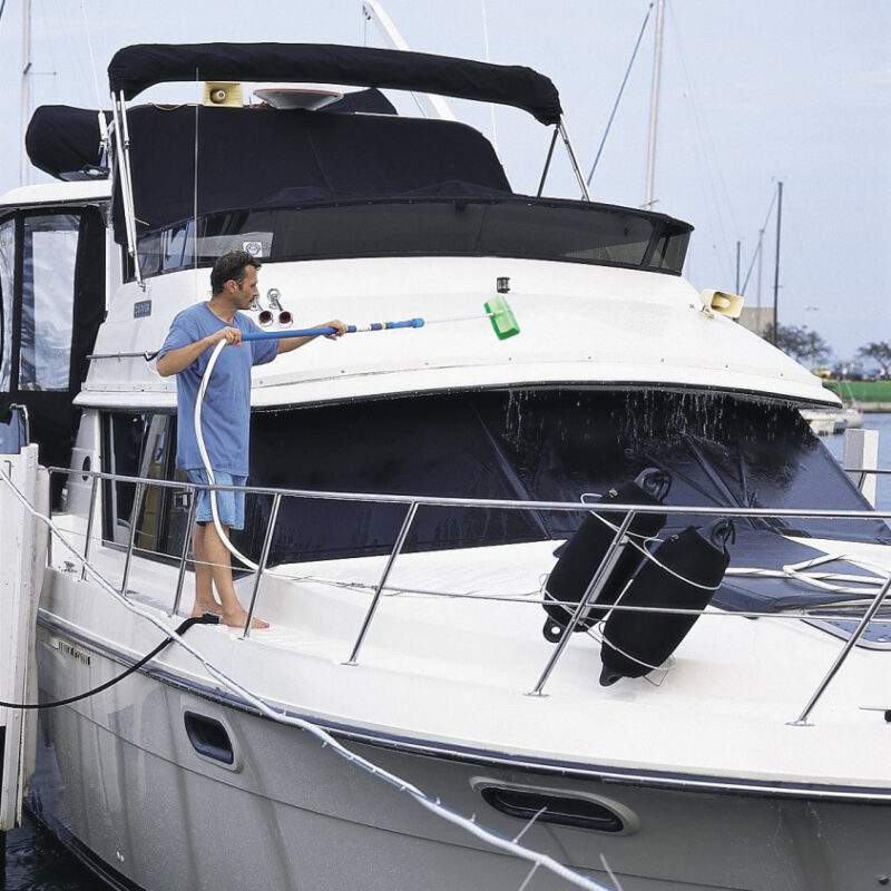 Man cleaning a large boat with the very soft bi-level brush and HydraSoar