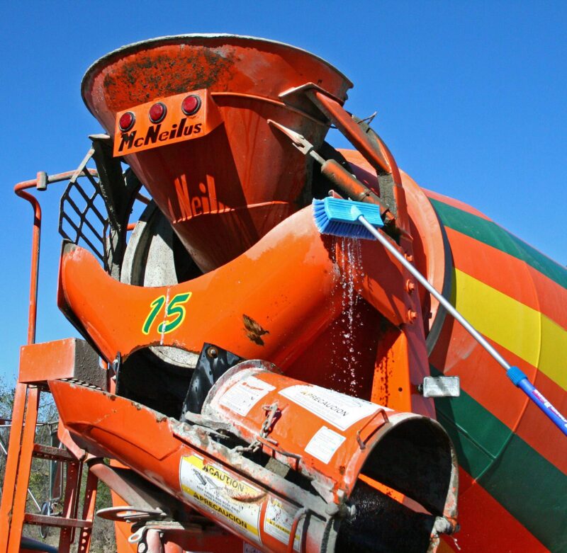 Blue bi-level brush cleaning a cement truck.