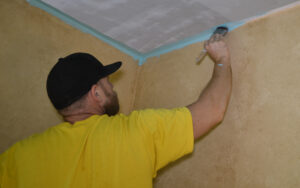 Cutting in the joint between the wall and the ceiling.