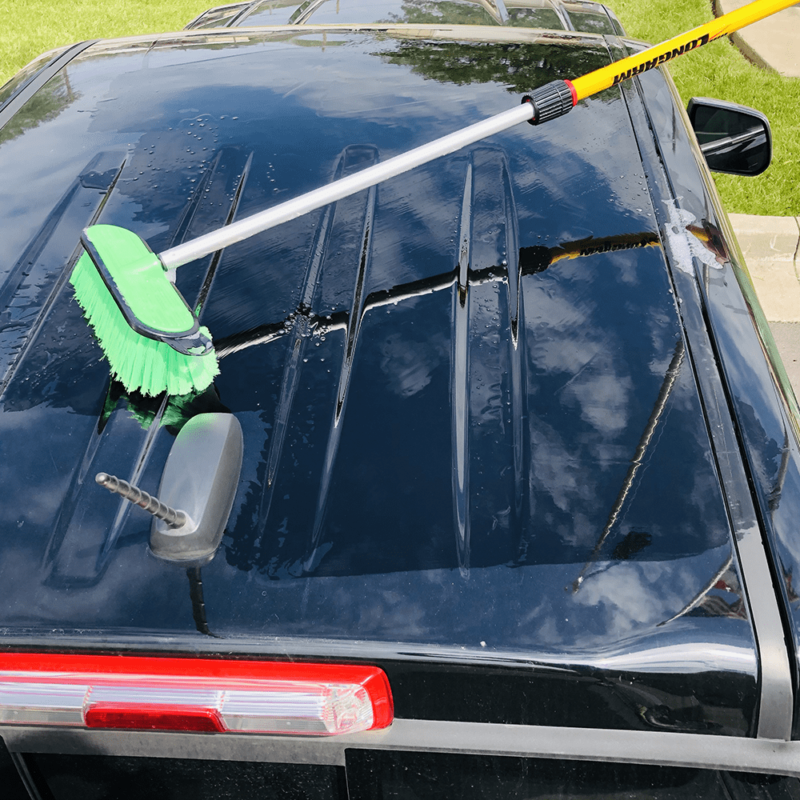 Pro-pole with a soft green brush washing a truck.