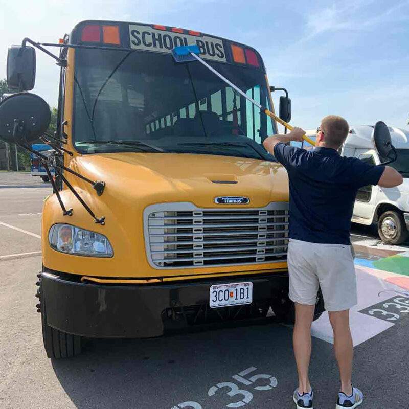 Truck 'n Bus pole cleaning a school bus using a blue bi-level brush