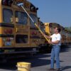 Cleaning school bus with a blue brush.