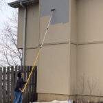Pro-Lok 3-section extension pole painting a 2-story house.
