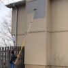 Pro-Lok 3-section extension pole painting a 2-story house.