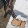 Using a paint tray to load stain onto the deck stain roller cover.