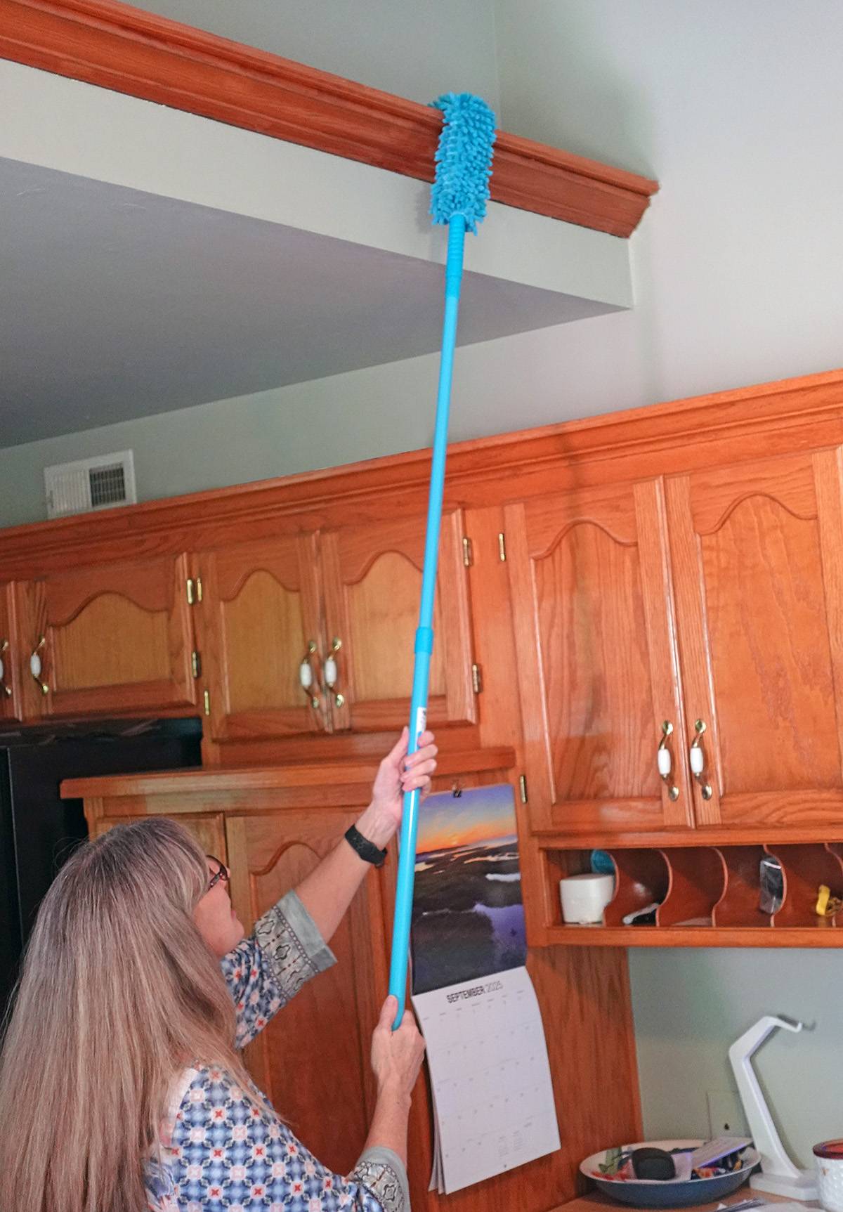 Dusting with the blue microfiber duster and pole